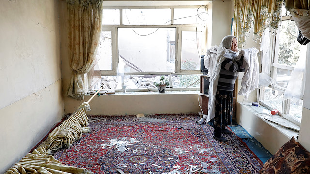 File photo: An Afghan woman collects curtains in her damaged house after yesterday's suicide bombing in Kabul, Afghanistan October 25, 2020