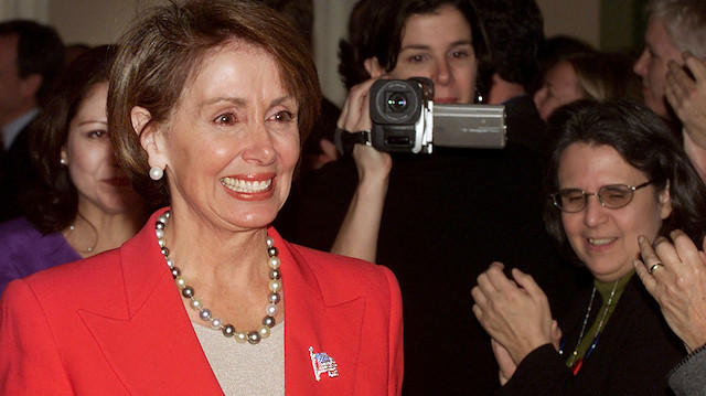 FILE PHOTO: Capitol Hill staffers applaud Representative Nancy Pelosi (D-CA) as she exits the caucus room, where she was elected House Minority leader, in the Cannon House office building November 14, 2002. REUTERS/Brendan McDermid/File Photo

