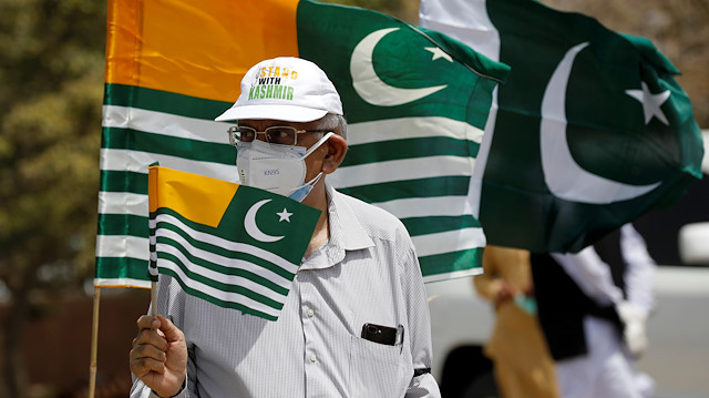 A man holds a flag as he observes a one-minute silence 