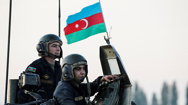 Azerbaijani soldiers look on from a tank 