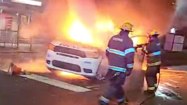 Firefighters hose down a burning police vehicle during protests after the death of Walter Wallace Jr., a Black man who was shot by police in Philadelphia, Pennsylvania, U.S., October 27, 2020 in this still image taken from social media video. Instagram @reef_gotcars_58 via Reuters