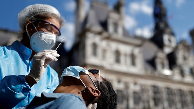 FILE PHOTO: A health worker, wearing a protective suit and a face mask, prepares to administer a nasal swab to a patient at a testing site for the coronavirus disease (COVID-19) installed in front of the city hall in Paris, France, September 2, 2020. REUTERS/Christian Hartmann/File Photo

