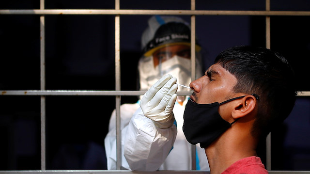File photo: A man reacts as a healthcare worker collects a swab sample amidst the spread of the coronavirus disease (COVID-19), at a testing centre, in New Delhi, India October 17, 2020. REUTERS/Adnan Abidi


