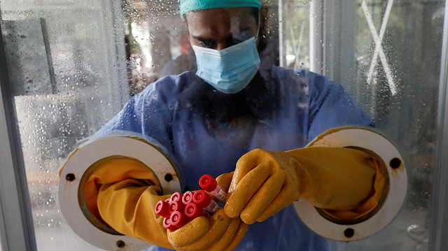 FILE PHOTO: A paramedic wearing protective gear at a glass booth, counting nose-swab samples to be tested for the coronavirus disease (COVID-19), in Karachi, Pakistan June 26, 2020. REUTERS/Akhtar Soomro/File Photo

