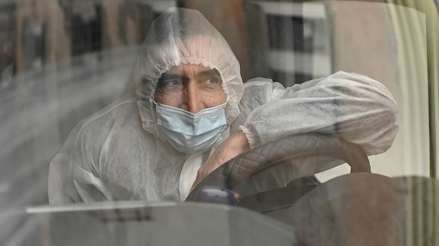A driver wearing personal protective equipment (PPE) sits in an ambulance outside a hospital amid the coronavirus disease (COVID-19) outbreak in Omsk, Russia October 28, 2020. REUTERS/Alexey Malgavko

