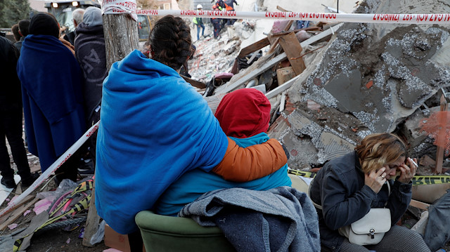 Relatives of people affected by an earthquake that struck the Aegean Sea stand on debris as they watch rescue operations in the coastal province of Izmir, Turkey, October 31, 2020. REUTERS/Murad Sezer

