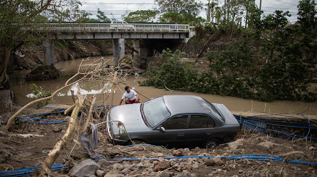 A man sits beside a car, washed away by floods caused by Typhoon Goni, in Barangay San Isidro, Batangas City, Philippines, November 2, 2020. REUTERS/Eloisa Lopez

