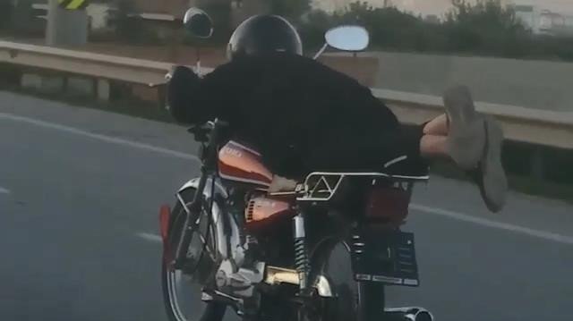 Plakasını söktüğü motosikleti yüzüstü yatarak kullandı