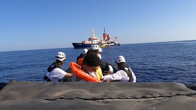 A rescue team with migrants heads to the Sea-Watch 4 ship on board of rubber dinghy, at sea off the coast of Libya, August 22, 2020, in this still image taken from the video. Sea-Watch/Handout via Reuters