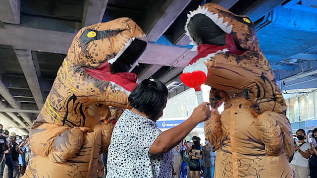 Dinosaur costumed actors representing Thailand's establishment at a high school 