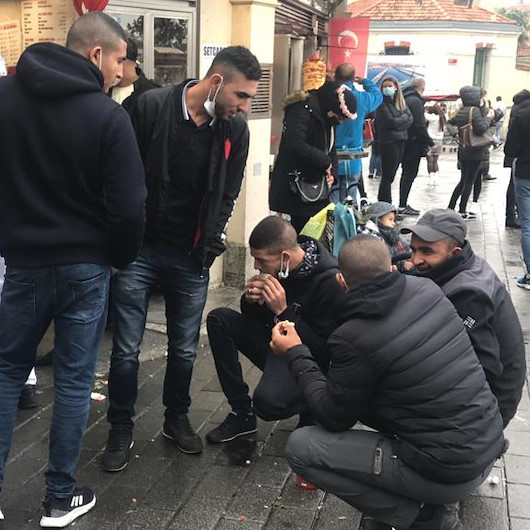 Koronavirüs tedbirleri kapsamında içeriye alınmayanlar büfe önünde çömelerek yemek yedi