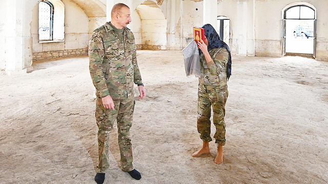 Aliyev çifti, zemininde halı bulunmayan camiye ayakkabılarını çıkarıp girdi.