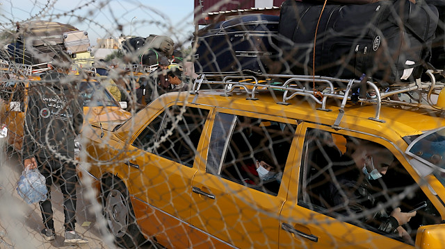 A Palestinian boy, seen through a fence, sits in a car as he waits to leave Rafah border crossing with Egypt, which was reopened partially amid the spread of the coronavirus disease (COVID-19), in the southern Gaza Strip November 24, 2020. 