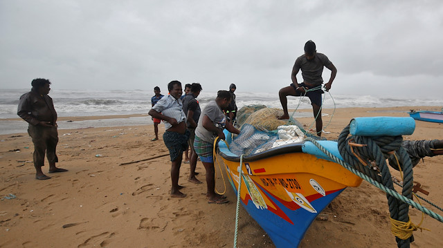 Fishermen tie their boat on the shore before Cyclone Nivar's landfall, in Chennai, India, November 25, 2020. 