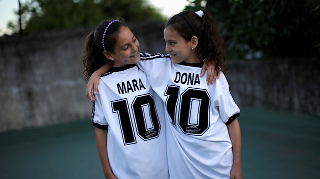 Mara and Dona, twin daughters of Walter Gaston Rotundo, a devoted Diego Maradona fan who named his daughters after the soccer star, pose for photos at their house, in Buenos Aires, Argentina, November 27, 2020