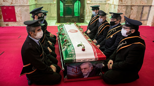 Mourners sit next to the coffin of Iranian nuclear scientist Mohsen Fakhrizadeh, during the burial ceremony at the shrine of Imamzadeh Saleh, in Tehran, Iran November 30, 2020. 