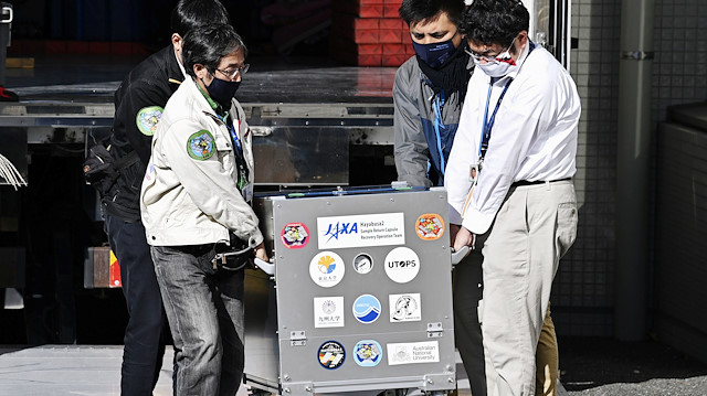Japan Aerospace Exploration Agency's (JAXA) staff carry a case containing Hayabusa2's capsule with extensive samples of an asteroid as it arrives at JAXA Sagamihara Campus in Sagamihara in this photo taken by Kyodo December 8, 2020. Mandatory credit Kyodo/via Reuters