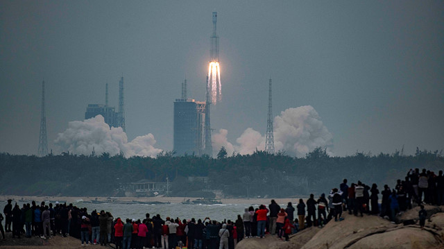People watch the medium-lift Long March 8 Y-1 rocket taking off from Wenchang Space Launch Center, on a beach in Wenchang, Hainan province, China December 22, 2020.