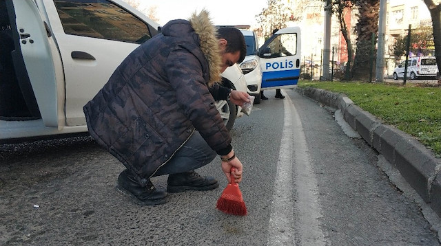 Narkotik polisi fırça ile asfalttan uyuşturucu süpürdü.