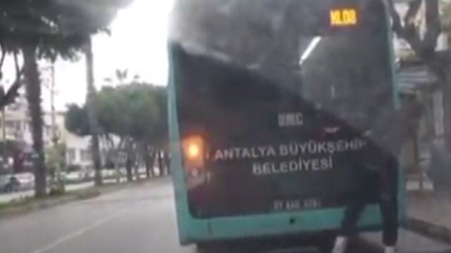 Otobüsün arkasına takılan patenli genç, şoförün fark etmesiyle koşarak kaçtı
