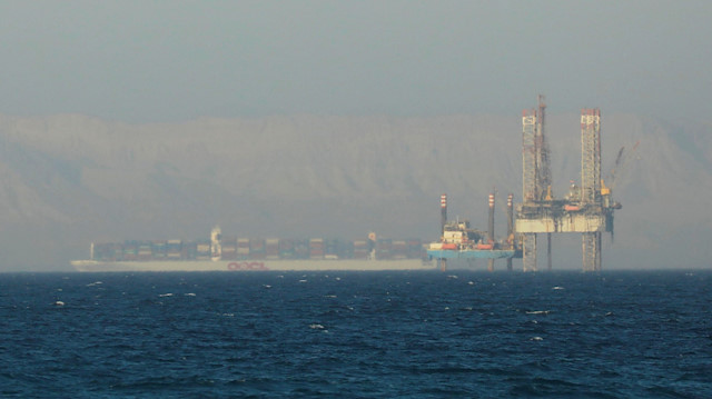 A container ship crosses an oil platform at the Gulf of Suez towards the Red Sea before entering the Suez Canal, outside of Cairo, Egypt September 1, 2020. Picture taken September 1, 2020.