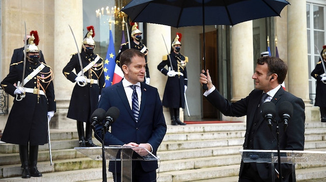 Fransa Cumhurbaşkanı Macron Slovakya Başbakanı’na şemsiye tuttu.
