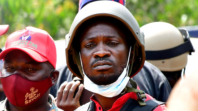 Ugandan opposition presidential candidate Robert Kyagulanyi also known as Bobi Wine (C) is escorted by policemen during his arrest in Kalangala, in central Uganda December 30, 2020.