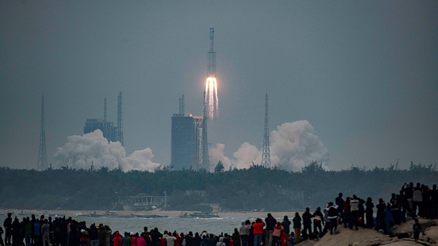 People watch the medium-lift Long March 8 Y-1 rocket taking off from Wenchang Space Launch Center, on a beach in Wenchang, Hainan province, China December 22, 2020.
