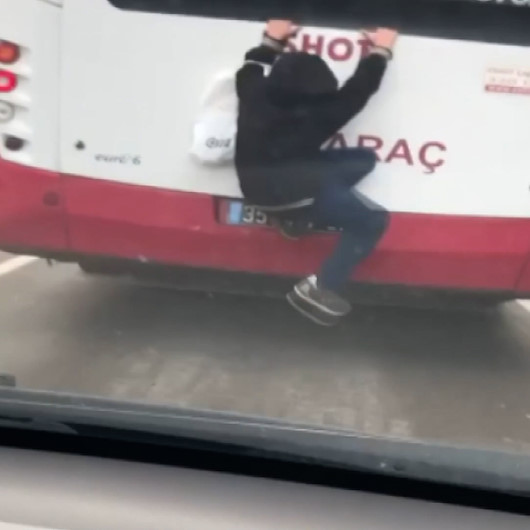 Hareket halindeki otobüse tutunan çocuk yürekleri ağza getirdi