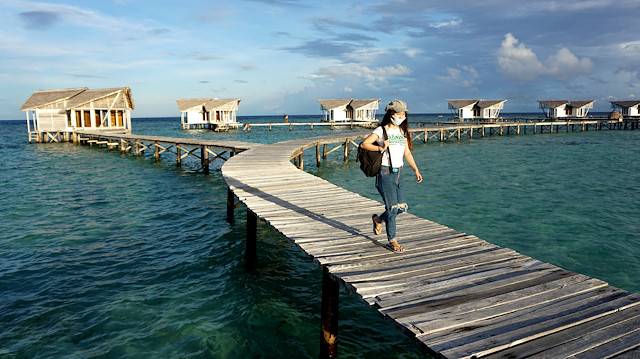 A woman walks on a bridge during the reopening of the touristic site Pulo Cinta Eco Resort, as the government eases restrictions amid the coronavirus disease (COVID-19) outbreak in Boalemo, Gorontalo Province, Indonesia June 18, 2020,