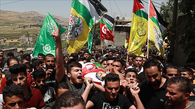 Filistin bayrakları taşıyan binlerce kişinin katıldığı törende tekbirler yükselirken, İsrail karşıtı sloganlar atıldı.