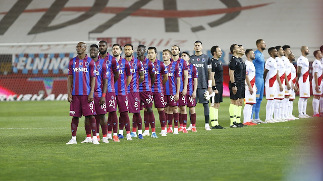 Bordo-mavili futbolcular İstiklal Marşı okunduğu sırada bayrağa dönüyor.