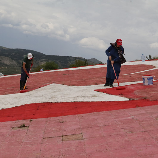 Yozgatlı vatandaş tepenin yamacındaki rengi solan Türk bayrağını boyadı