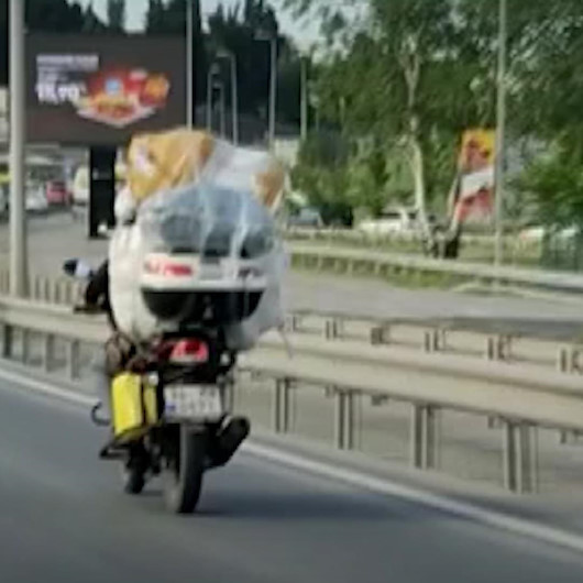 Motosikletine fazla yük alan sürücü hem kendini hem trafiği tehlikeye attı