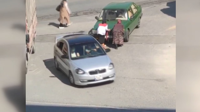 Yolda kalan aracı gören kağıt toplayıcısı kadın otomobili iterek yardımcı oldu