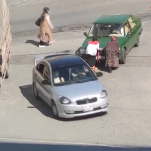 Yolda kalan aracı gören kağıt toplayıcısı kadın otomobili iterek yardımcı oldu