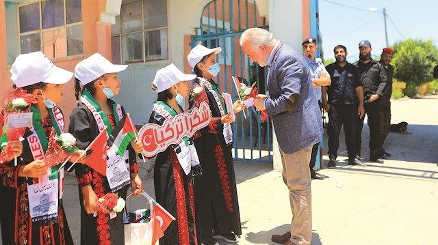Gazze'ye giden Kerem Kınık, Filistin ve Türkiye bayrakları taşıyan El-Emel Yetimhanesi'ndeki çocuklar tarafından karşılandı.