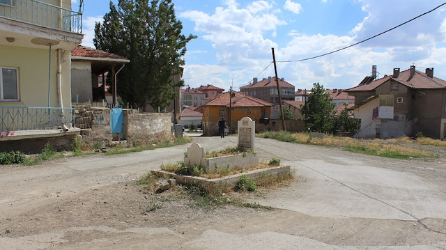 Bir evin bahçesinde bulunan mezar, evler yıkılınca yol ortasında kaldı. 