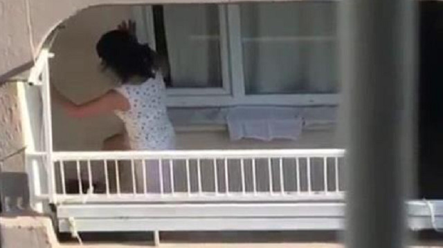 Kadın balkonundaki köpeğe vurdu ve tekme attı.