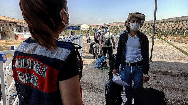 Suriyelilerin sınır kapısında polis ve jandarma gözetiminde kayıtları yapılıyor.