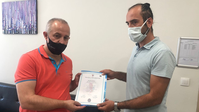  Bertan Müdüroğlu (solda) diplomayı Öğretim Görevlisi Gürkan Erdoğan’dan teslim aldı.