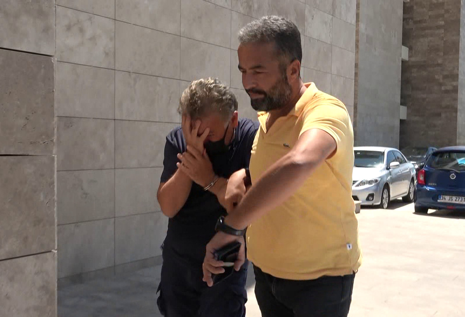 Mustafa Murat Ayhan emniyete götürülürken yüzünü gizlemeye çalıştı.