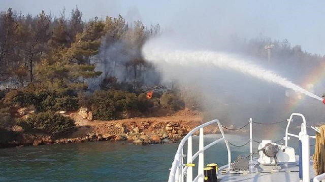 Kıyı Emniyeti Genel Müdürlüğü ekibi, Marmaris'te devam eden orman yangınını söndürme çalışmalarına denizden destek veriyor.