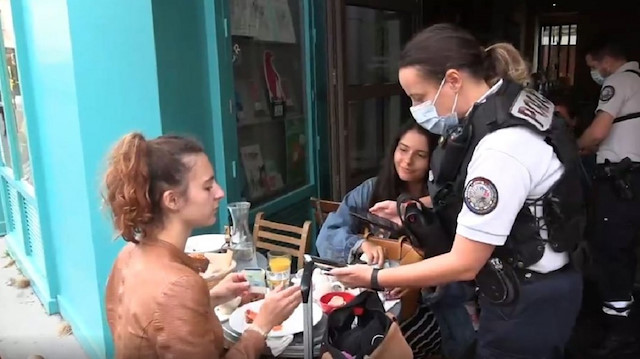 ​Fransa'da polis sağlık kartlarını kontrol ediyor. 