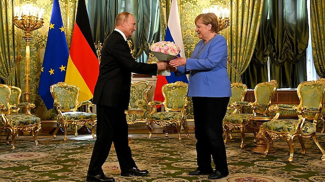Rus lider Putin Merkel’le görüşmesine çiçekle geldi