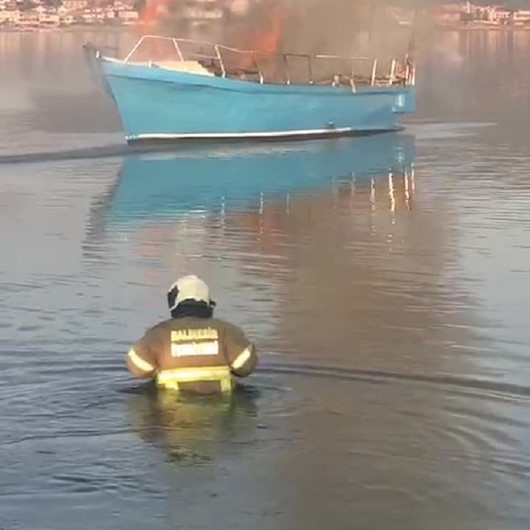 Balıkesirde itfaiyeciler tekneyi söndürmek için kıyafetleri ile denize girdi