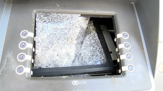 Kırılan bankamatik ekranlarının camları yola saçıldı. 