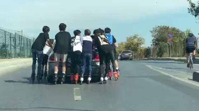 Yedi çocuğun aynı anda arabaya tutunarak gittiği anlar kameraya yansıdı.