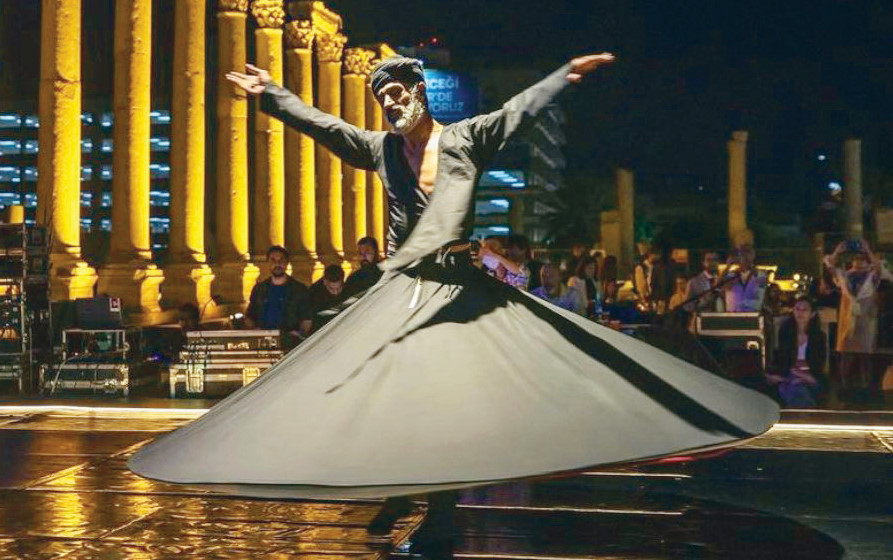 Ziya Azazi isimli dansçı başında sarık ve üstte siyah, altta kırmızı 2 kat Mevlevi kıyafeti ile sahneye çıktı.