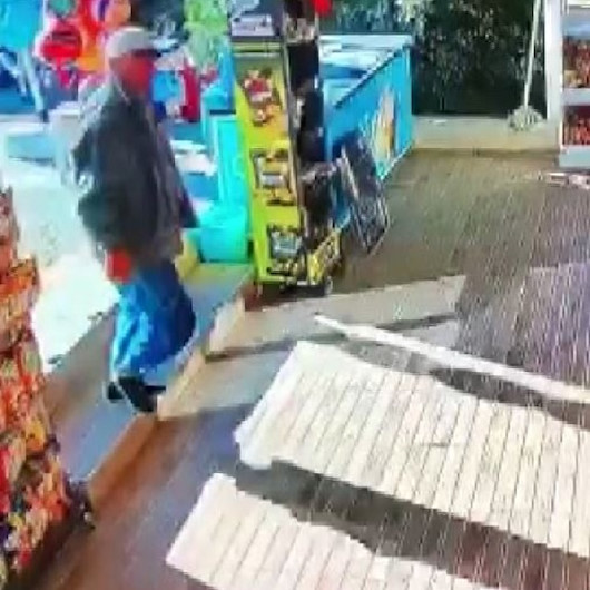Antalyada market kirlenmesin diye çamurlu ayakkabılarını çıkarıp çoraplarıyla içeri girdi